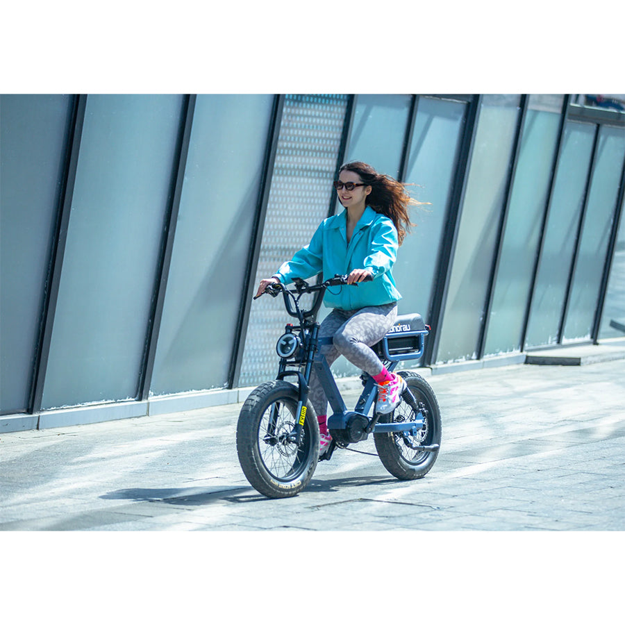 Woman riding Eunorau Flash e-bike by building