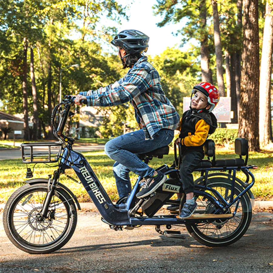 Woman on the bike with a child on the rear rack with cushions