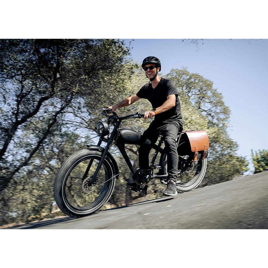 Man riding the black variant with saddle bag on the back